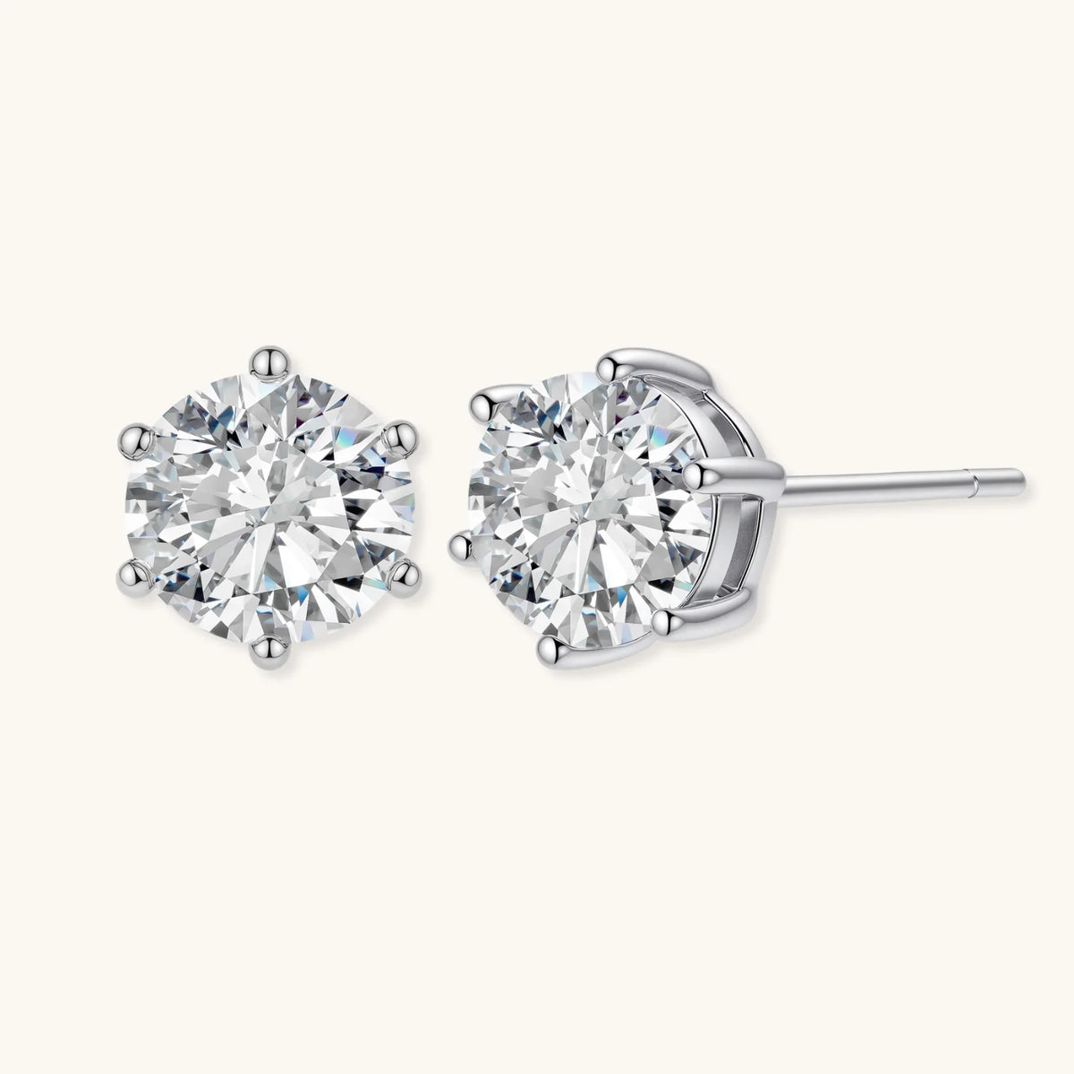 Pair of round moissanite stud earrings in sterling silver six-prong settings, angled view showing the post