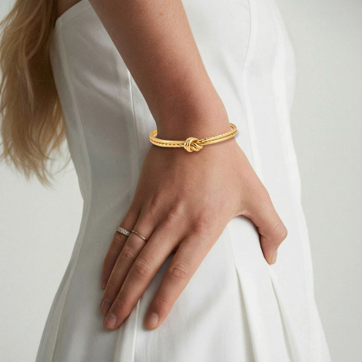 Close-up of a woman's wrist wearing the gold knot cuff bracelet