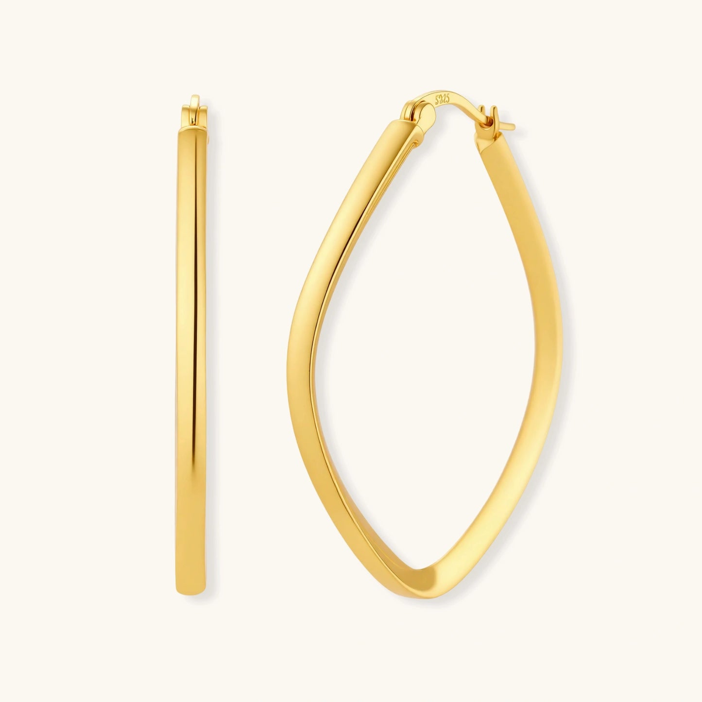 Set of geometric gold-plated sterling silver hoop earrings in oval and cushion shapes on cream background