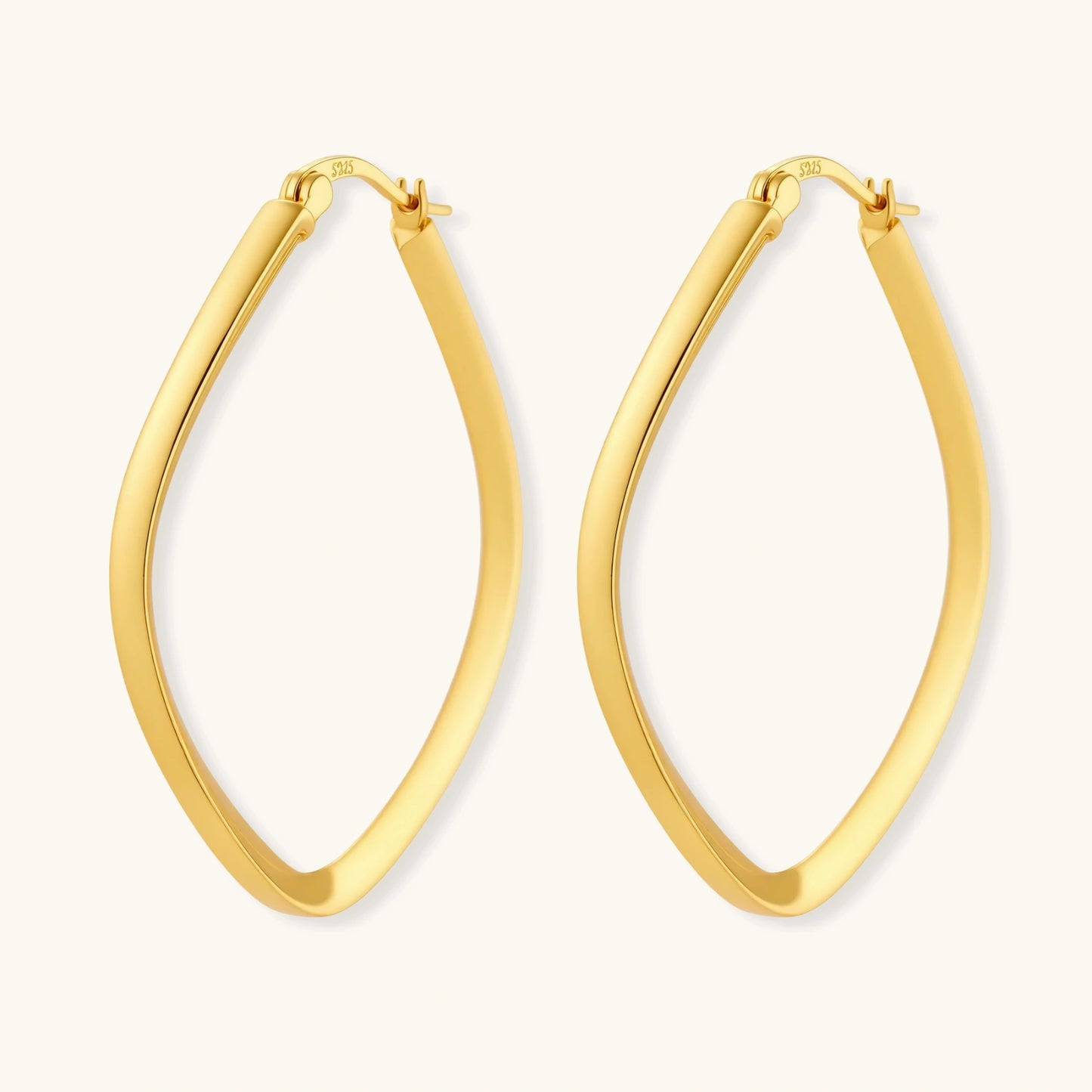 Set of geometric gold-plated sterling silver hoop earrings in oval and cushion shapes on cream background