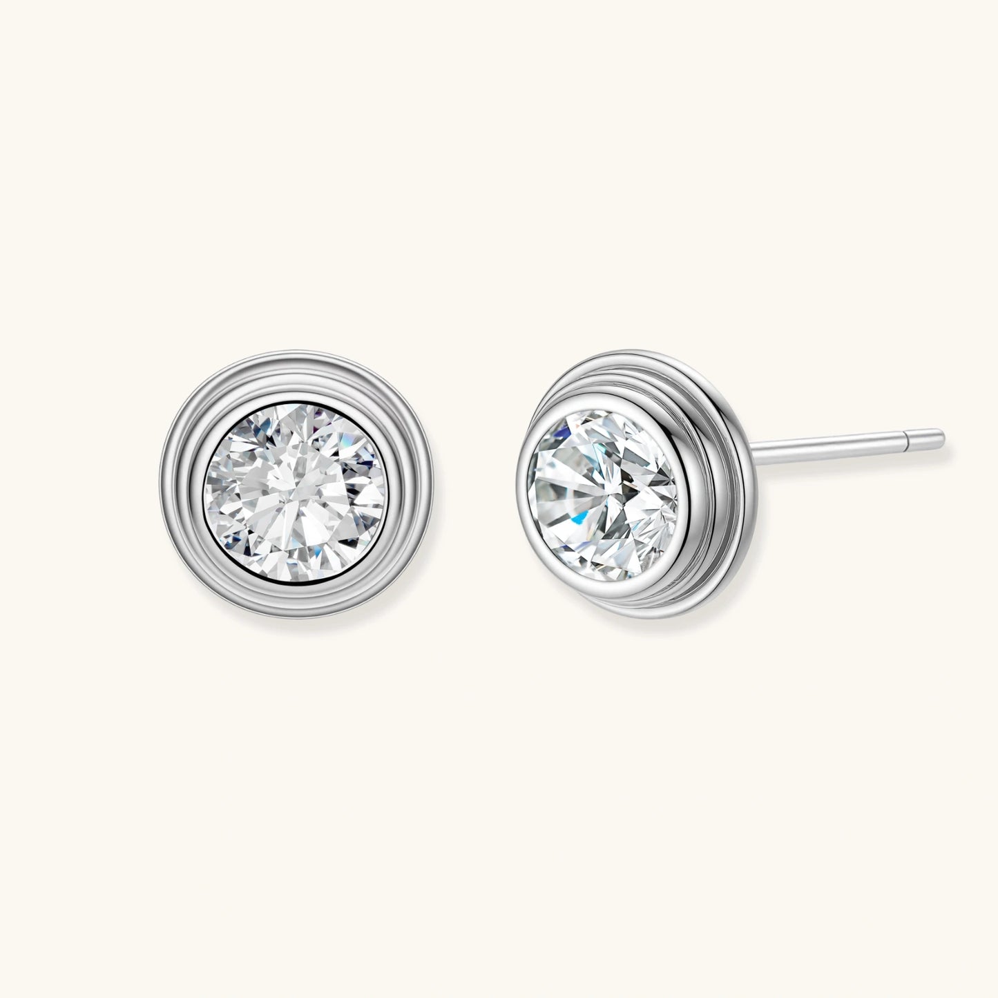 Close-up of sterling silver stud earrings featuring concentric circular frames with brilliant moissanite centers