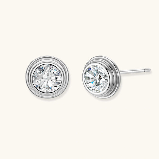 Close-up of sterling silver stud earrings featuring concentric circular frames with brilliant moissanite centers