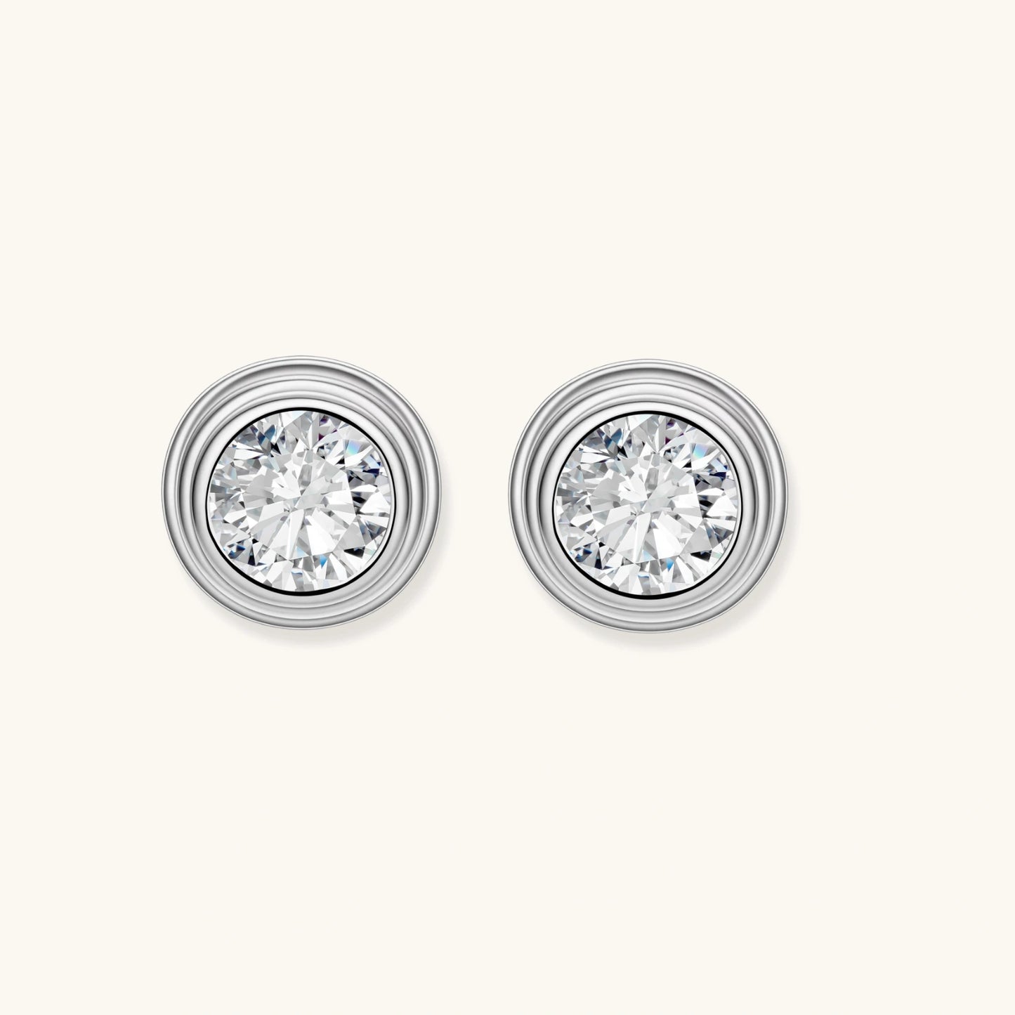 Close-up of sterling silver stud earrings featuring concentric circular frames with brilliant moissanite centers