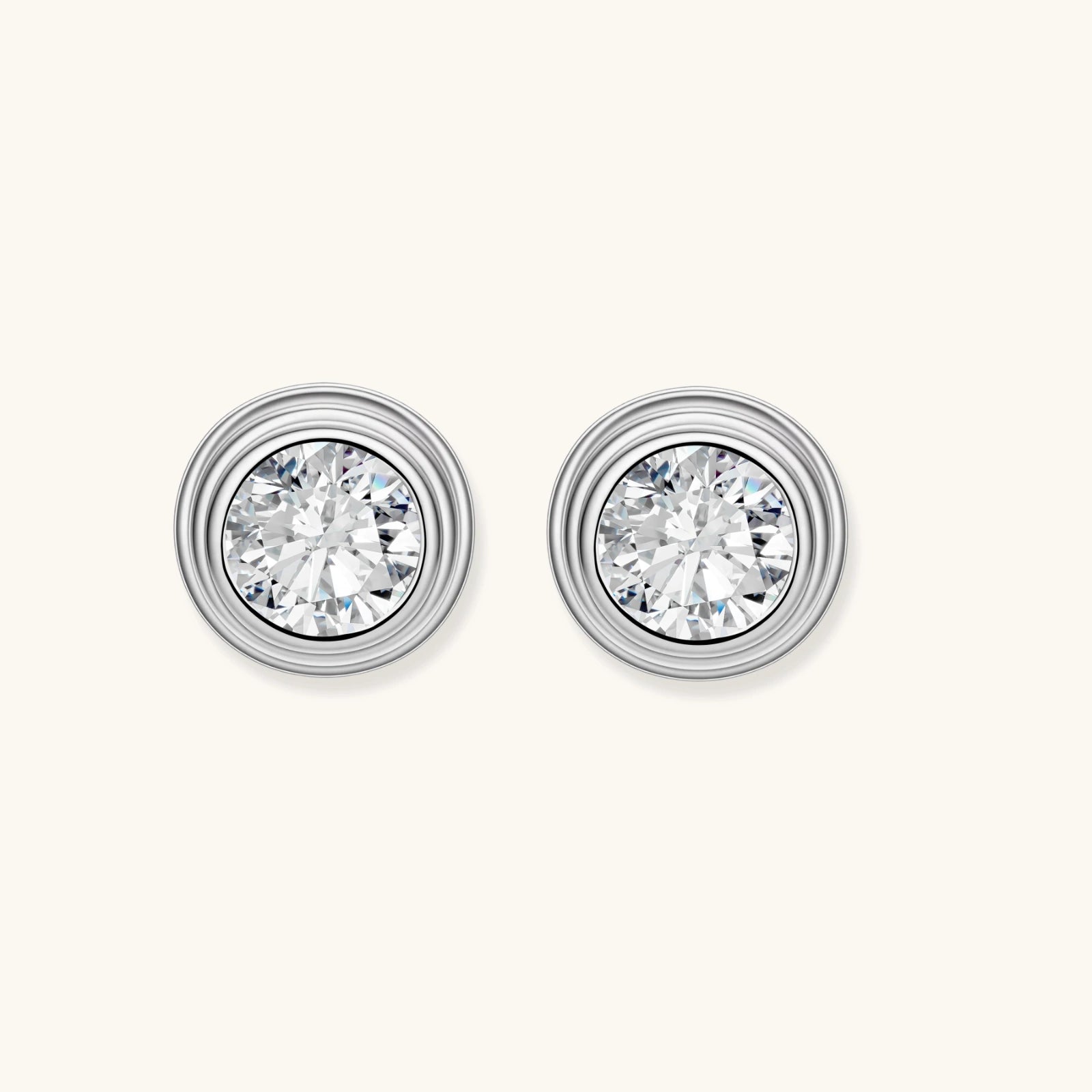 Close-up of sterling silver stud earrings featuring concentric circular frames with brilliant moissanite centers